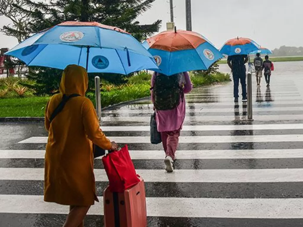 Ilustrasi orang menggunakan payung saat hujan turun. (ANTARA FOTO/Anggoro)