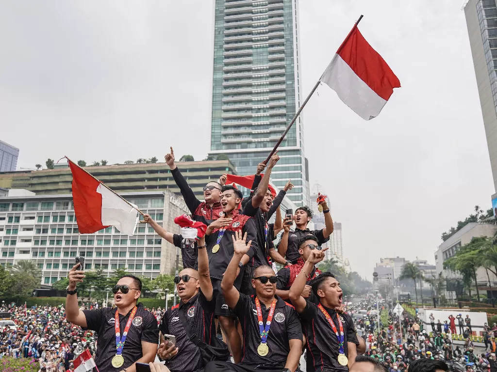 Timnas Indonesia U-22 bersama ofisial dan pengurus PSSI berada di atas bus saat melintas dalam arak-arakan Kira87uara Kontingen SEA Games 2023 di Bundaran HI, Jakarta, Jumat (19/5/2023). (ANTARA FOTO/Sigid Kurniawan)