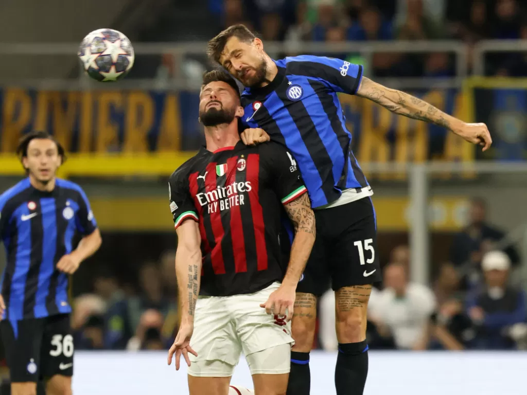 Bek Inter Milan, Francesco Acerbi, berduel dengan penyerang AC Milan, Olivier Giroud, pada semifinal Liga Champions 2022/2023. (REUTERS/Claudia Greco)