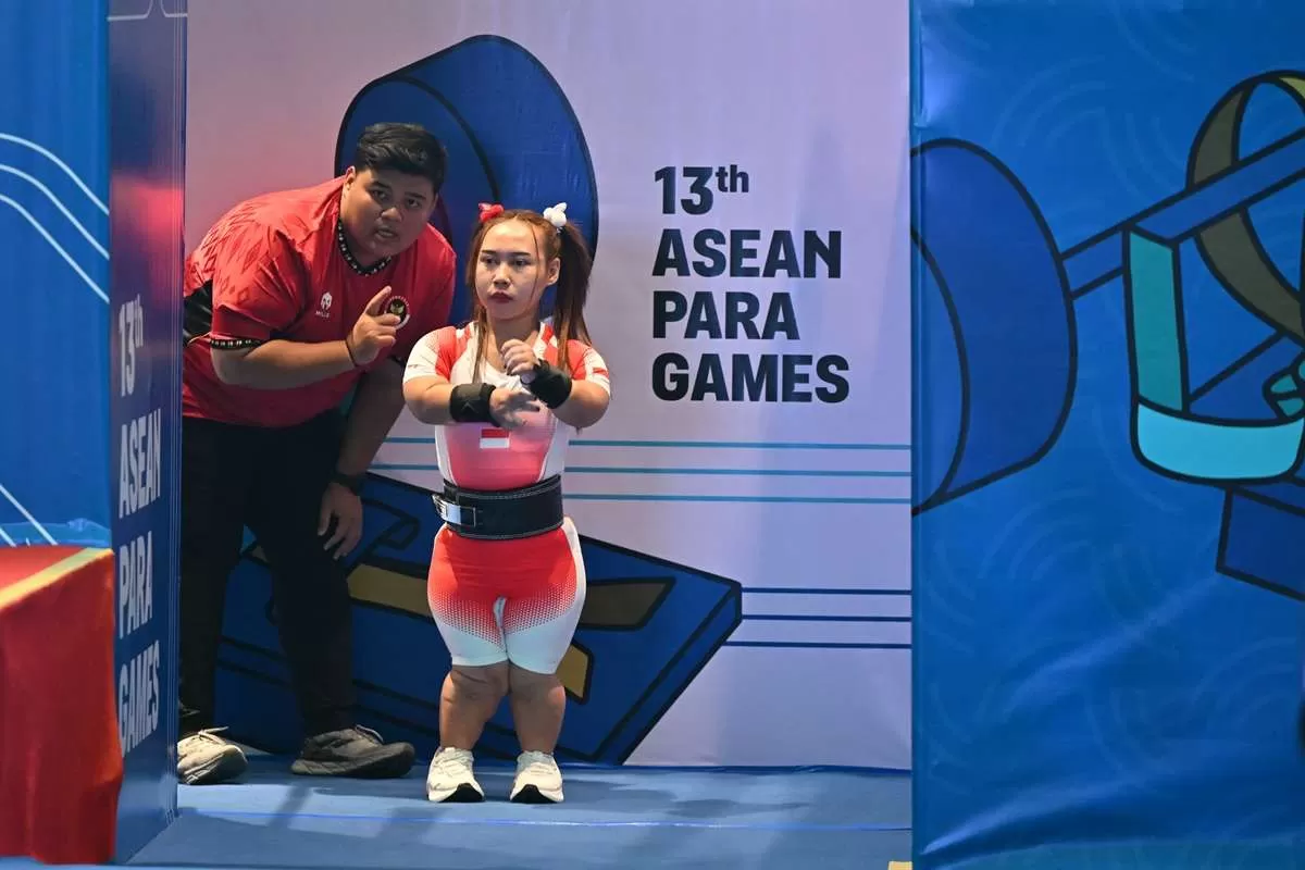 Lifter NPC Indonesia Eliana (kanan) mendengarkan instruksi dari pelatih sebelum pertandingan cabang olahraga para angkat berat nomor 41kg putri ASEAN Para Games 2025 di Convention Hall, Center Point Hotel, Nakhon Ratchasima, Thailand, Rabu (21/1/2026). Eliana tampil gemilang di laga debutnya dengan meraih medali emas lewat angkatan 78kg. (KlikSoloNews/dok NPC INDONESIA/Agung Wahyudi)