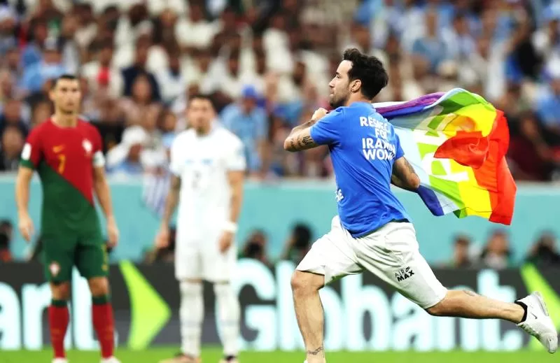 Cristiano Ronaldo melihat suporter berkaus Superman berlari ke tengah lapangan untuk melakukan protes saat laga Portugal Vs Uruguay di Piala Dunia 2022. (Foto: yahoosports)