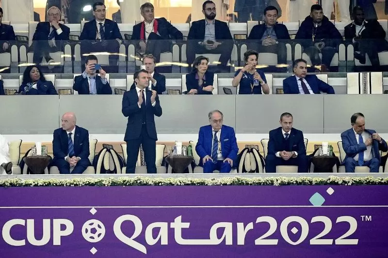 Emmanuel Macron berdiri memberi dukungan timnas Prancis saat melawan Maroko di semifinal Piala Dunia 2022. (Foto: san diego tribune)