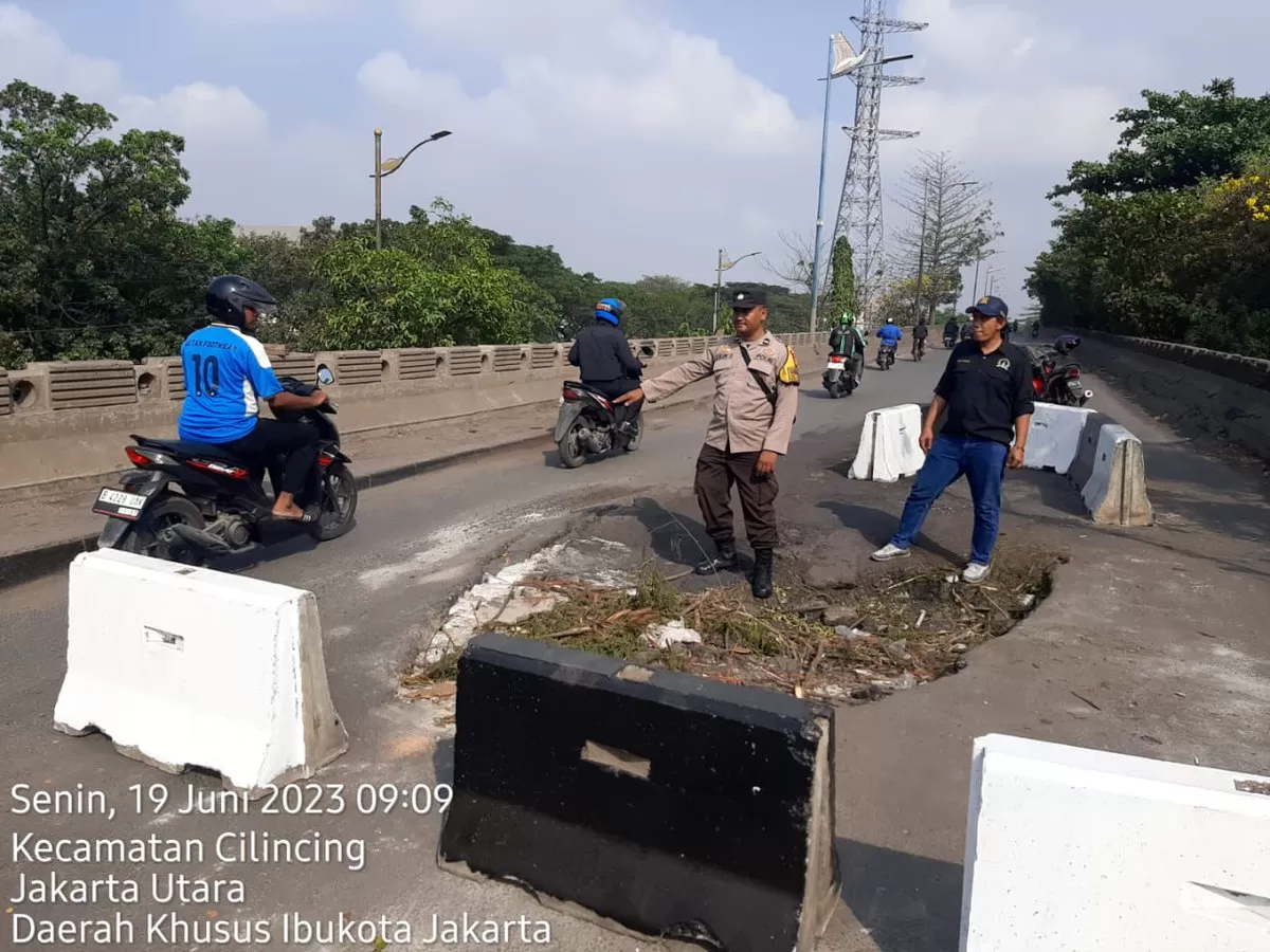 Kondisi jalan yang rusak dan berlubang besar terlihat di atas jembatan yang menghubungkan akses Marunda. 