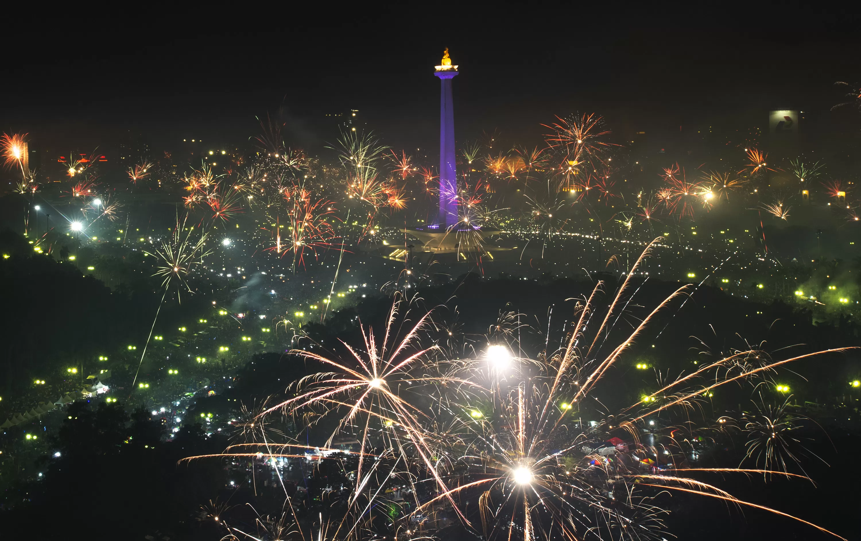 Warga menyalakan kembang api untuk merayakan malam pergantian tahun baru di kawasan Monumen Nasional (Monas), Jakarta. (Foto: Antara)