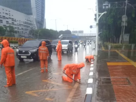 Sejumlah anggota petugas Penanganan Prasarana dan Sarana Umum (PPSU) dari Kelurahan Kebon Bawang, Kecamatan Tanjung Priok, Jakarta Utara, saat untuk menangani genangan air di Jalan Yos Sudarso, dekat Kantor Wali Kota Jakarta Utara, pada Kamis, 29 Februari 2024. (Foto: beritajakarta.id)