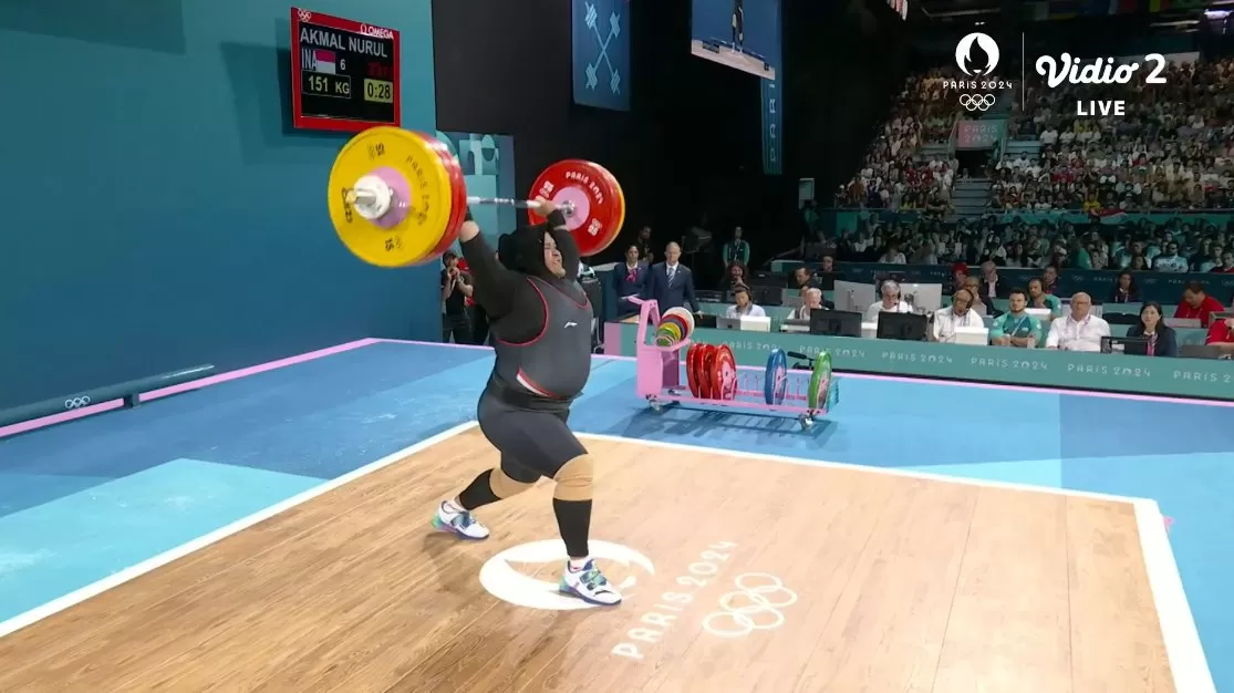 Lifter Nurul Akmal saat beraksi melakukan angkat beban di nomor +81 kg putri Olimpiade Paris 2024. Foto: X tangkapan layar Vidio/@BadmintonTalk