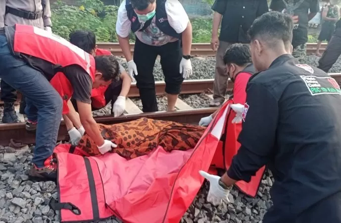 Petugas mengevakuasi jasad korban yang tertabrak kereta api di Gondang Sragen. (Foto: Said Masykuri)