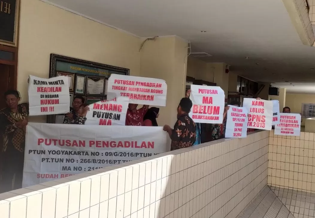 Para guru dan tenaga honorer membawa poster dan spanduk saat mendatangi kantor BKN Regional 1 Yogyakarta. (Foto : Wahyu Priyanti)