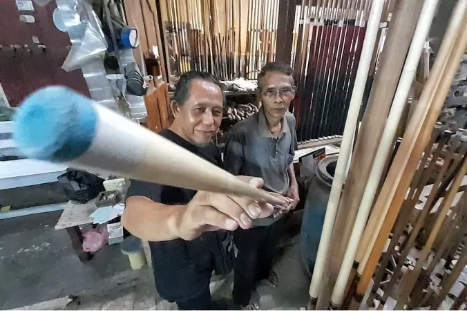 Welas (70) melayani konsumen yang akan membeli stik billiard di Kampung Billiard Ambarawa. (Foto: Chandra AN)