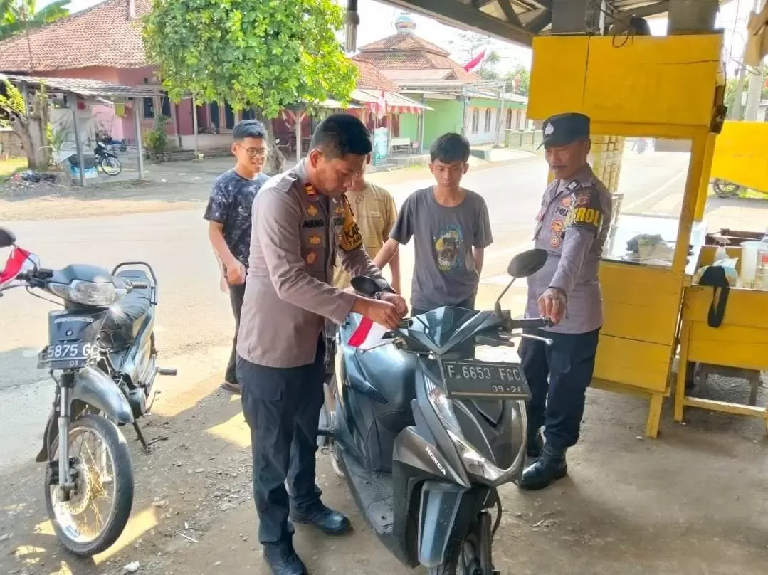 Kapolsek Tanjungsari Bagikan Bendera Merah Putih ke Warga dan Ponpes Darul Mutaalimin