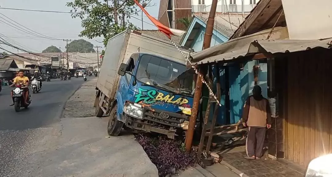 Diduga mengantuk, Mobil Box tabrak Rumah Warga di Jalan Raya Cicadas.