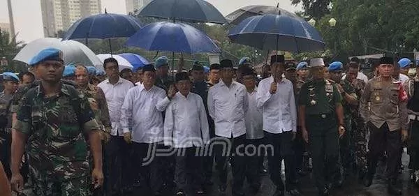 Presiden Joko Widodo dan Wakil Presiden Jusuf Kalla saat berjalan menuju lokasi Aksi 212 di Monas untuk salat Jumat.