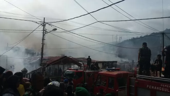 Petugas pemadam kebakaran saat memadamkan api yang membakar bangunan di Gang Senggol, Pasar Baru, Sungaipenuh