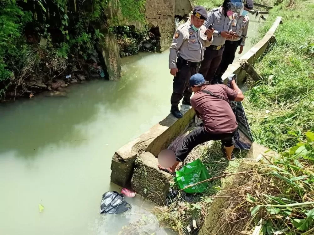 Petugas kepolisian dibantu warga mengevakuasi mayat bayi yang ditemukan di kawasan objek wisata Danau Sipin, Kota Jambi, Minggu (31/10) 