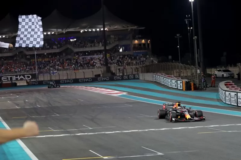 Pebalap tim Red Bull Max Verstappen melintasi garis finis untuk menjuarai Grand Prix Abu Dhabi di Sirkuit Yas Marina, Minggu (12/12/2021)