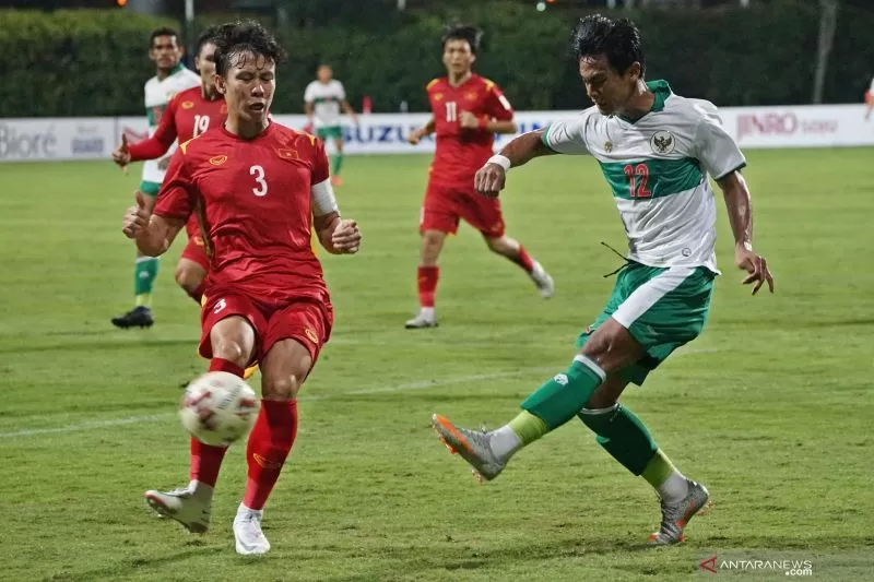 Pesepak bola Timnas Indonesia Pratama Arhan (kanan) berebut bola dengan pesepak bola Timnas Vietnam Que Ngoc Hai (kiri) dalam pertandingan grup B Piala AFF 2020 di Stadion Bishan, Singapura, Rabu (15/12/2021)