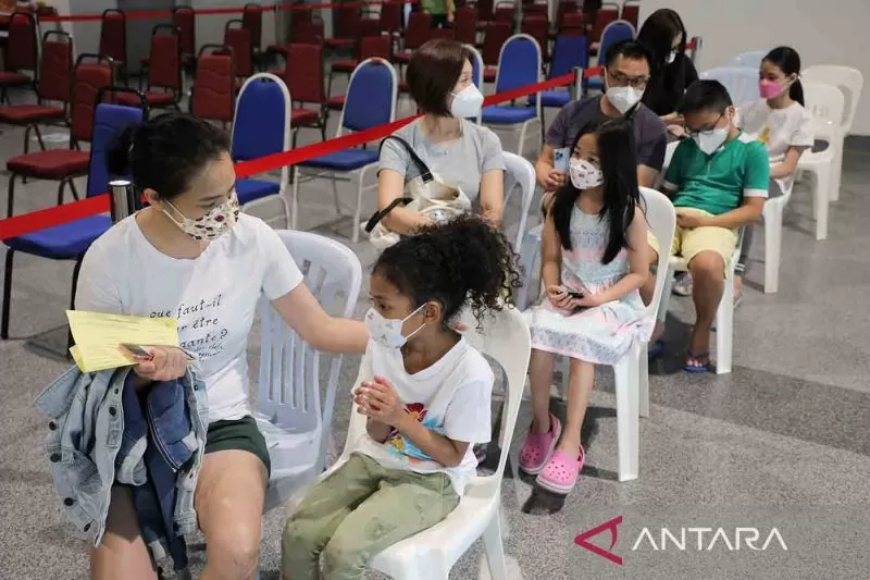 Para orang tua menemani anak mereka untuk menerima dosis pertama vaksin Pfizer di Kuala Lumpur, Malaysia, Kamis (3/2/2022). Pemerintah Malaysia memulai vaksinasi untuk anak-anak berusia antara 5 tahun dan 11 tahun.