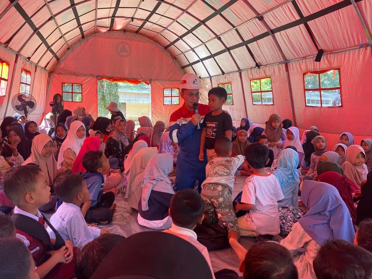 Siswa-siswi Yayasan Pendidikan Dharma Patra Rantau mengikuti proses belajar mengajar sekolah darurat di landasan helipad PEP Rantau Field, Selasa (6/1/2026). (Dok. PEP Rantau Field)