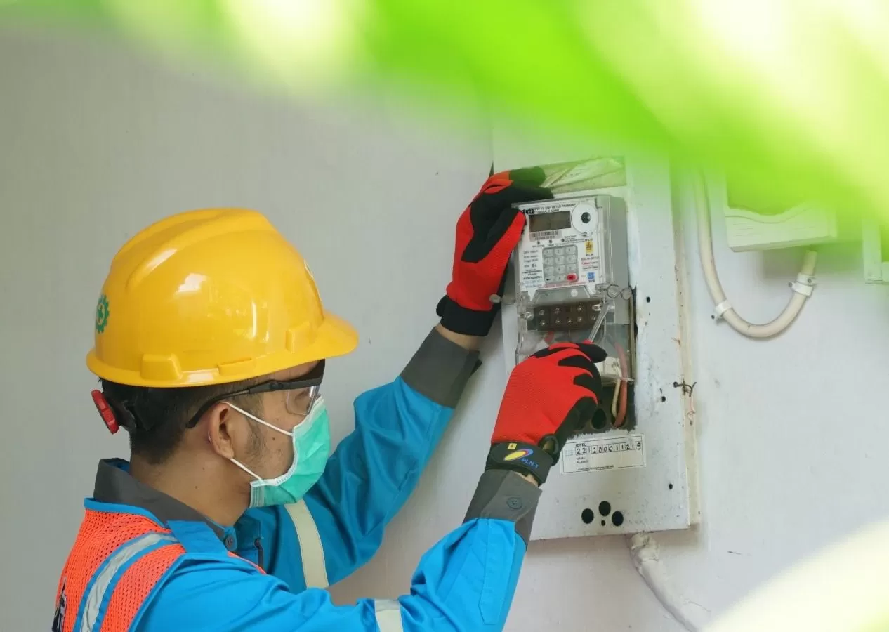 Ilustrasi petugas PLN saat menyesuaikan Miniature Circuit Breaker (MCB) pada kWh meter pelanggan yang membutuhkan layanan penyambungan listrik sementara. (Dok. PLN)
