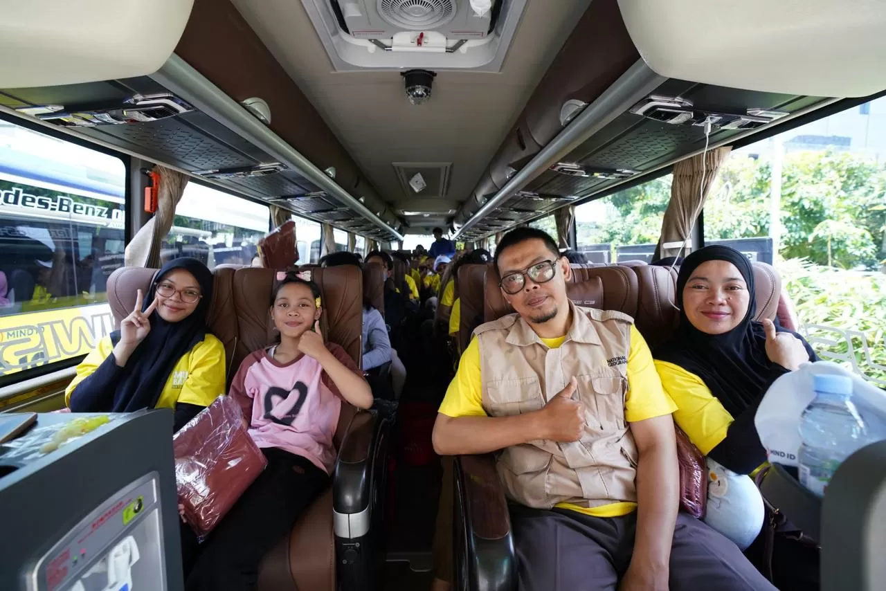 Tampak senyum sumringah para peserta Mudik Bareng Sektor ESDM 2026 sesaat sebelum bus diberangkatkan menuju rute tujuan mudik dari Kantor Kementerian ESDM, Jakarta pada Selasa (17/3). (Dok. PLN)