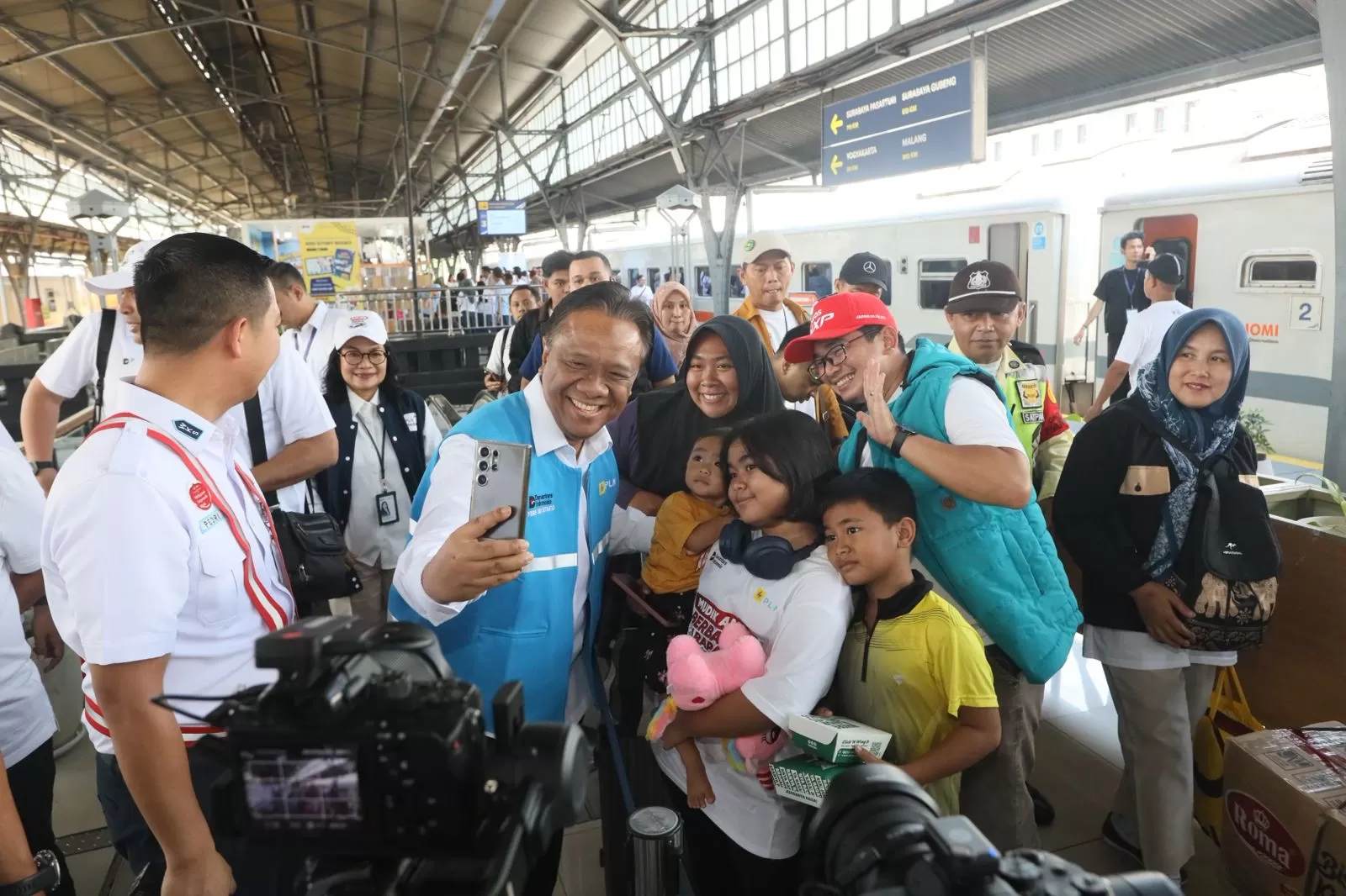 Direktur Legal dan Manajemen Human Capital PLN, Yusuf Didi Setiarto swafoto bersama peserta Mudik Gratis BUMN di Stasiun Pasar Senen, Jakarta pada Selasa (17/3). (Dok. PLN)
