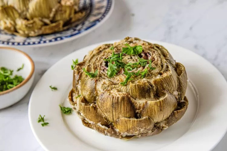 Stuffed artichoke dari Italia berupa artichoke yang diberi isi dari keju parut, bubuk roti, olive oil, bawang putih, dan parsley segar.   (allrecipes.com)