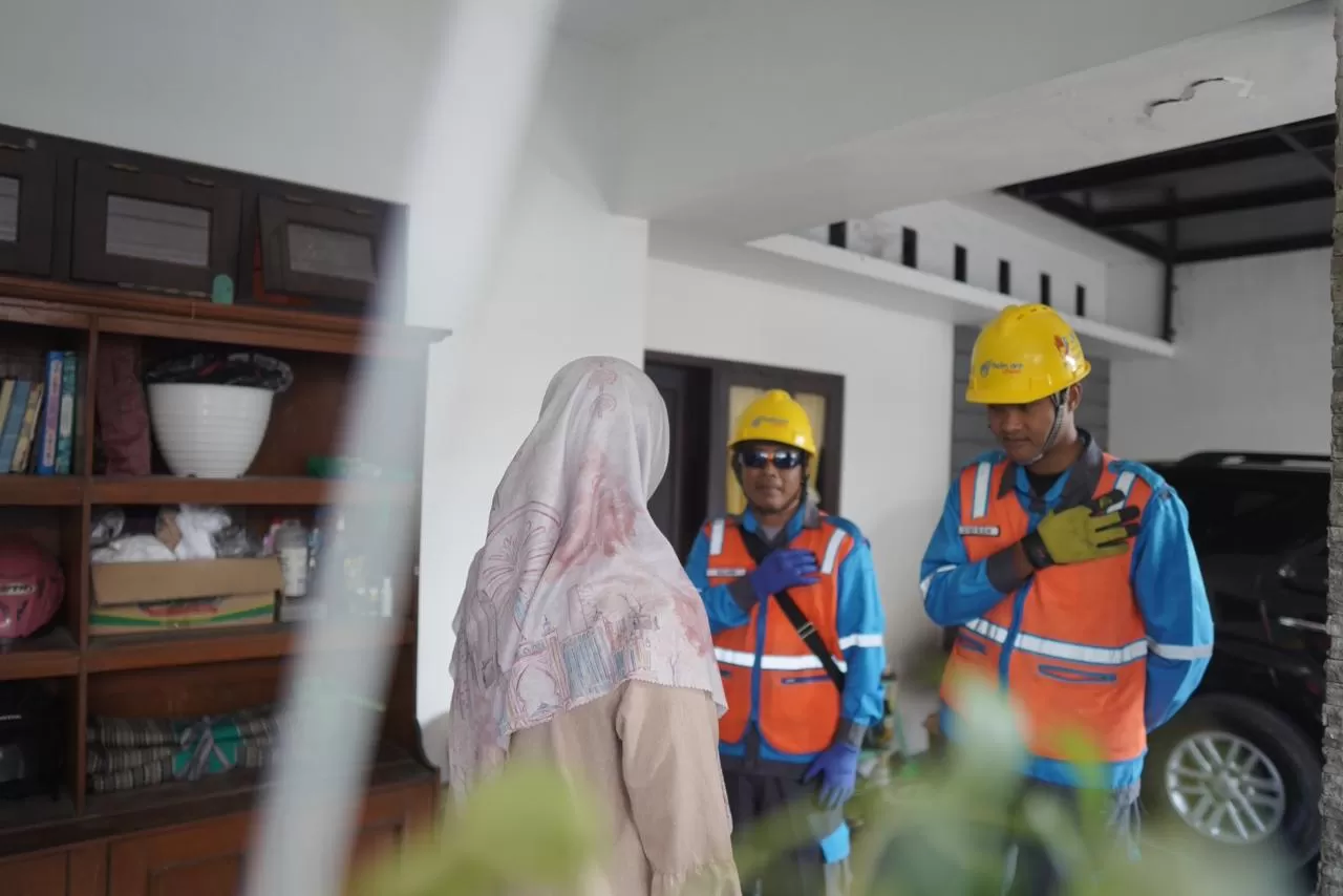 Petugas PLN tengah berinteraksi dengan pelanggan sebelum melakukan proses penambahan daya listrik di rumah pelanggan. (Dok. PLN)