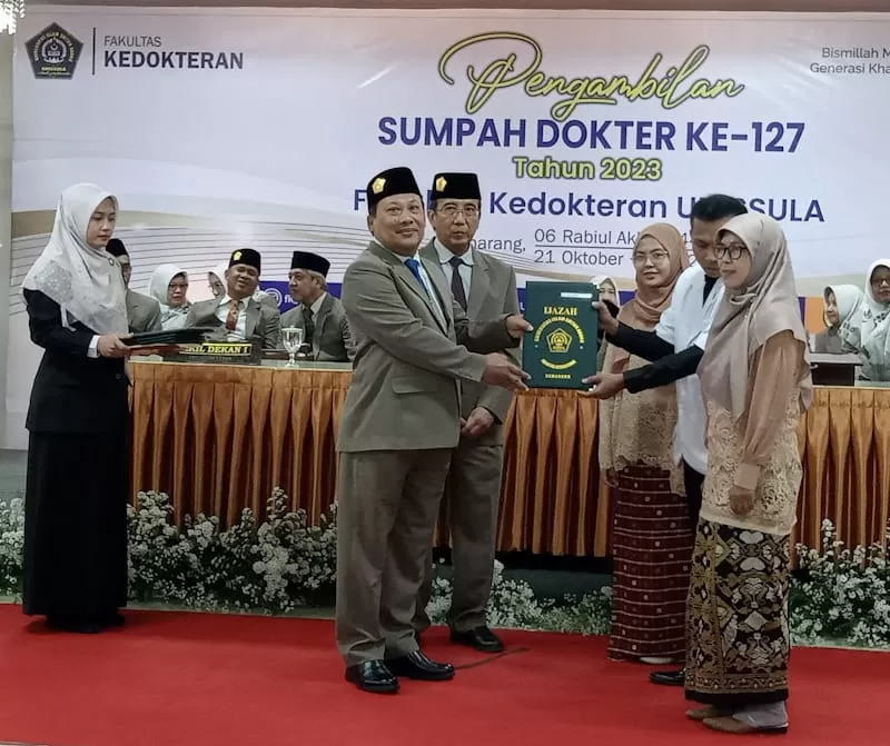 Dekan (kiri) saat menyerahkan ijazah kepada dokter baru (foto Sugeng I)