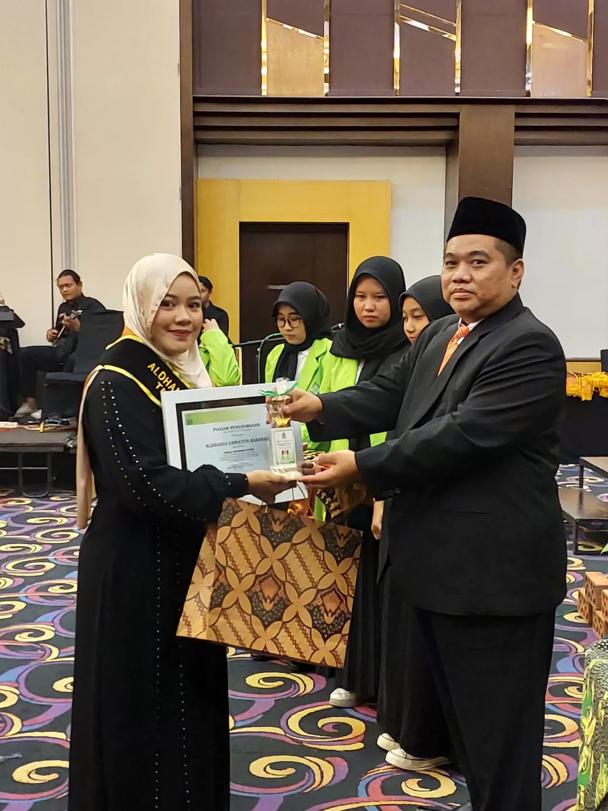 Wisudawan terbaik saat menerima penghargaan dari kampus