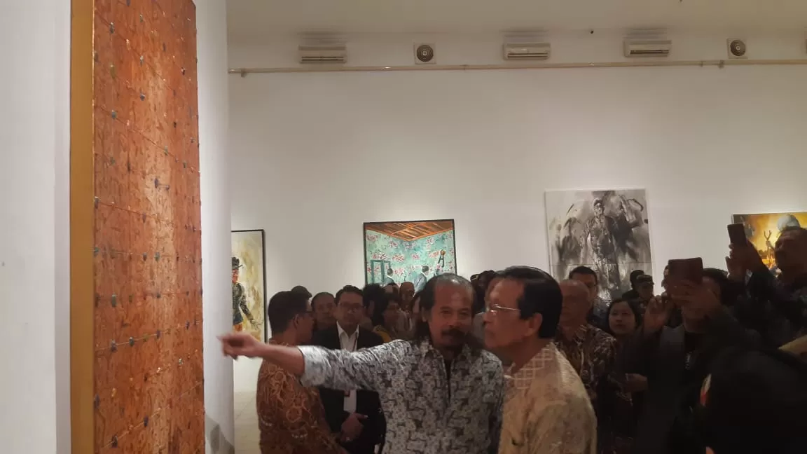 Perupa Nasirun menjelaskan karya lukisannya kepada Sri Sultan HB X.&nbsp;Foto : Khocil Birawa