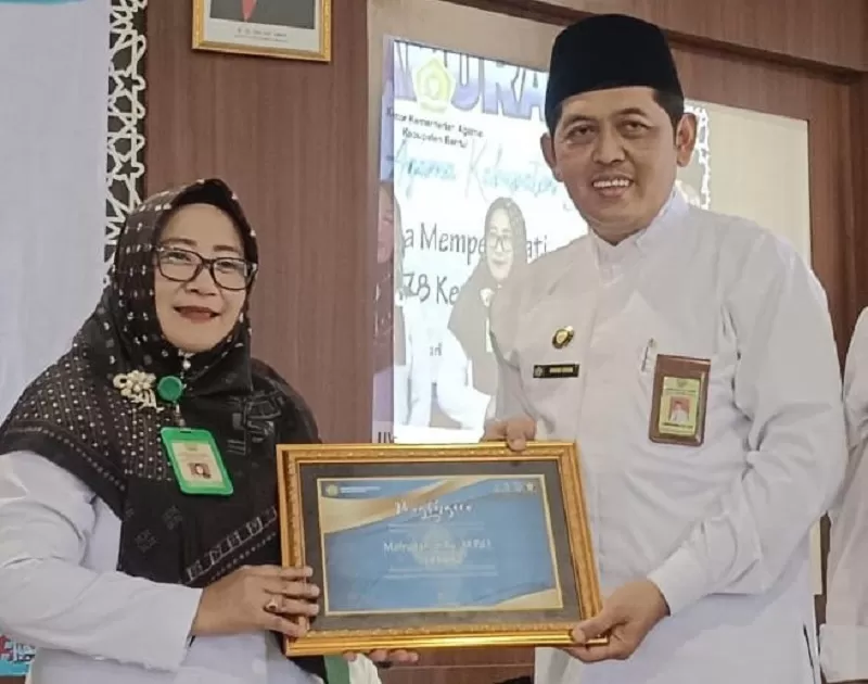  Kepala MTs Negeri 6 Bantul, Mafrudah, menerima penghargaan dari Kepala Kantor Kemenag Bantul Ahmad Shidqi. (Foto: Istimewa)