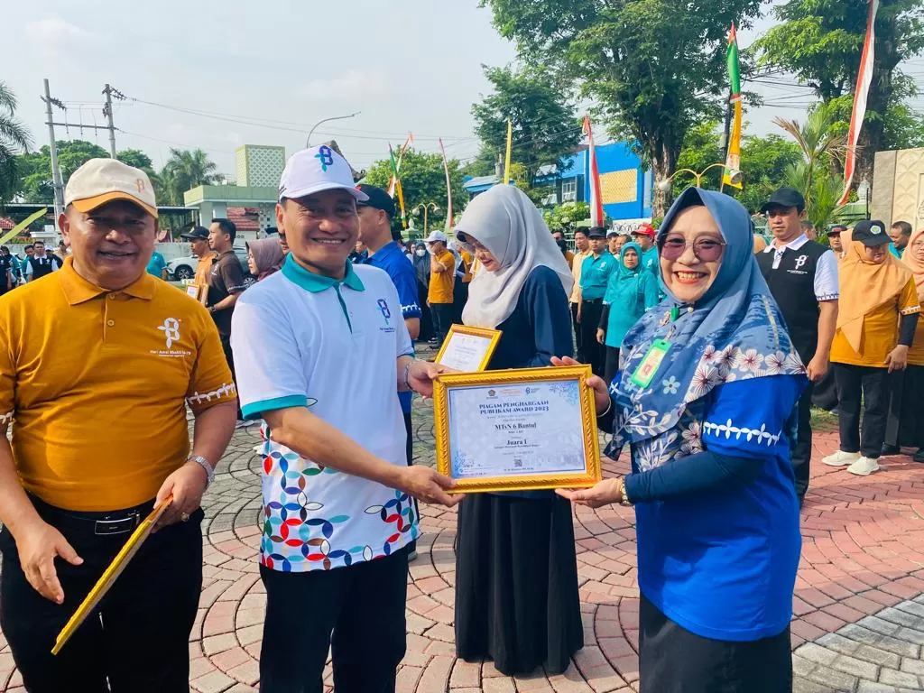 Kakanwil Kemenag DIY Masmin Afif menyerahkan penghargaan kepada Kepala MTsN 6 Bantul, Mafrudah. (Foto: Istimewa)