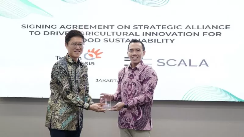 Direktur Digital Business Telkom Muhamad Fajrin Rasyid (kanan) menyerahkan cindera mata kepada Presiden Scala Jepang Norikatsu Nagino (Dok. Telkom)