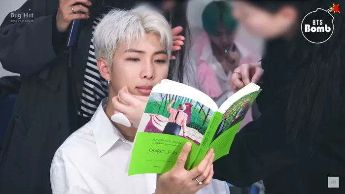 Foto RM anggota BTS sedang membaca buku. Sumber: Youtube BTS