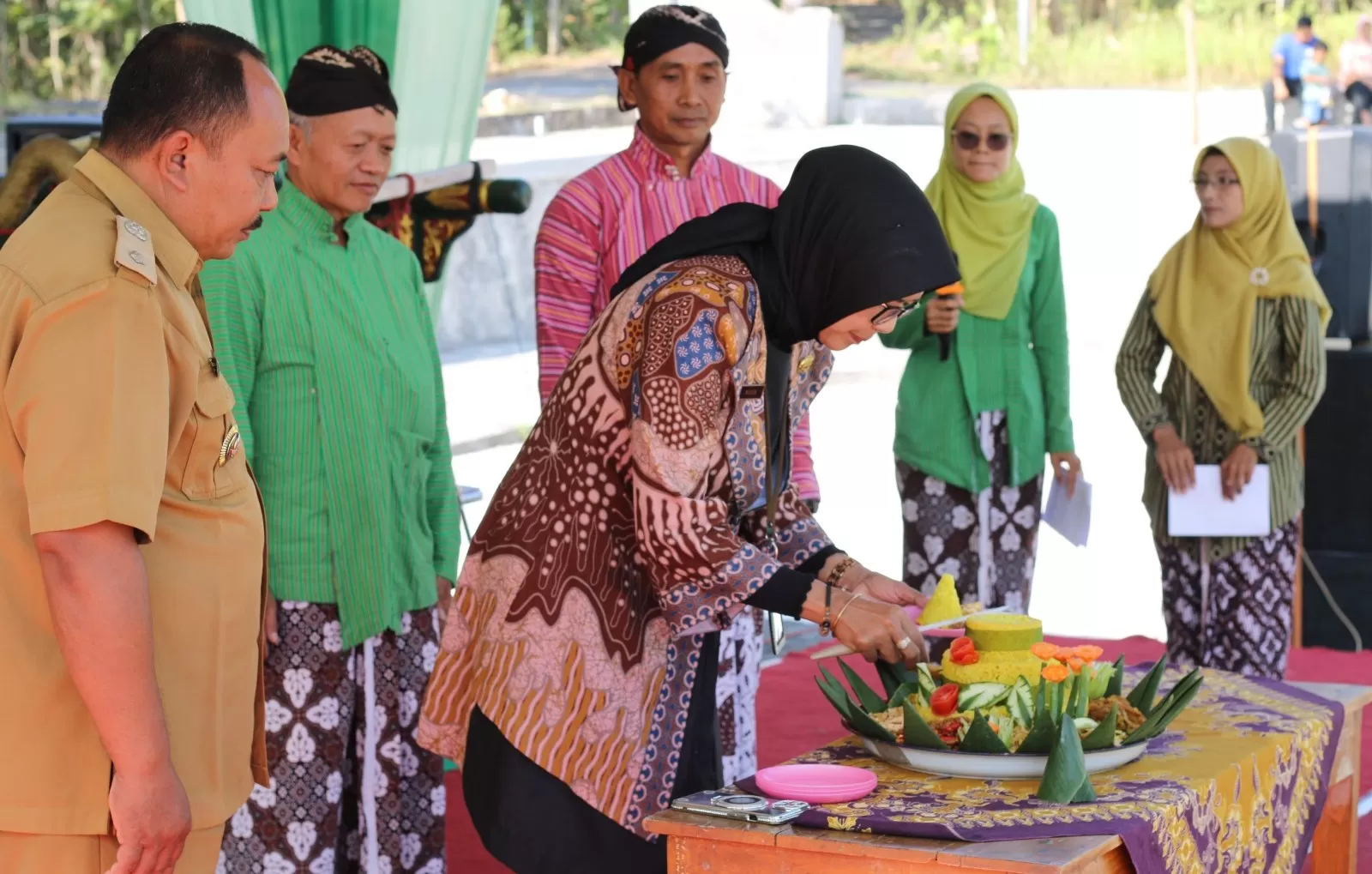 Nunuk Setyowati memotong tumpeng. (Dedy EW)