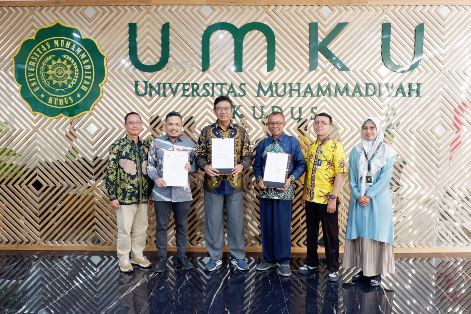 KU (3 dari ) diapit Rektor UM Jambi dan UM Kotabumi saat menunjukkan MOU.