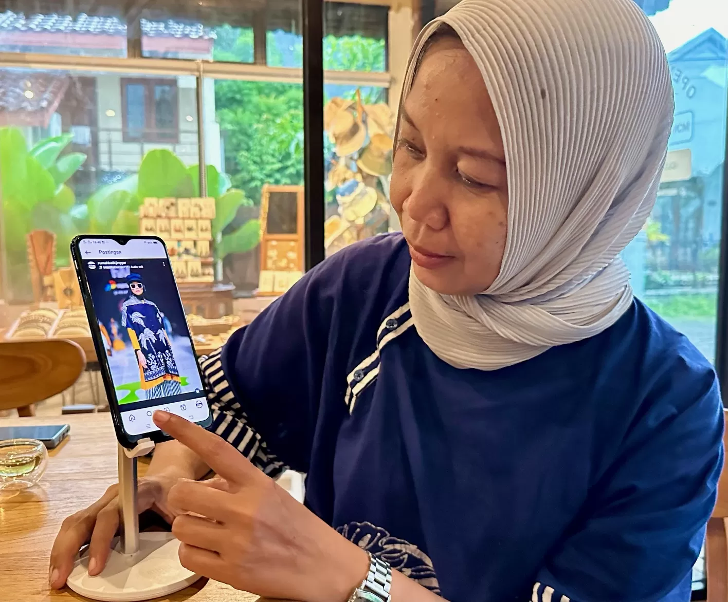 Vitalia menunjukkan Instagram Batik Jinggar yang berusaha dimaksimalkan perluas pasar digital (Harminanto)