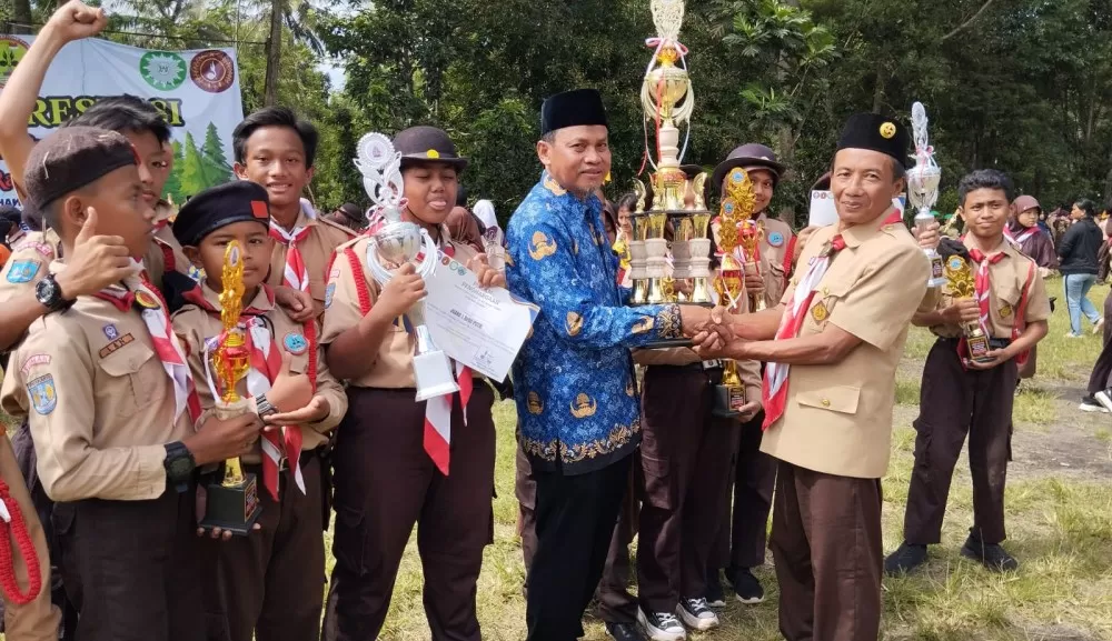  Ketua Majelis Pembimbing Gugus Depan (Kamabigus) SDN Maguwoharjo I Mulyadi, S.pd menerima tropi piala bergilir sebagai juara umum Kemah Prestasi   Tahun 2025  (Foto : Istimewa/Kwarran Depok)