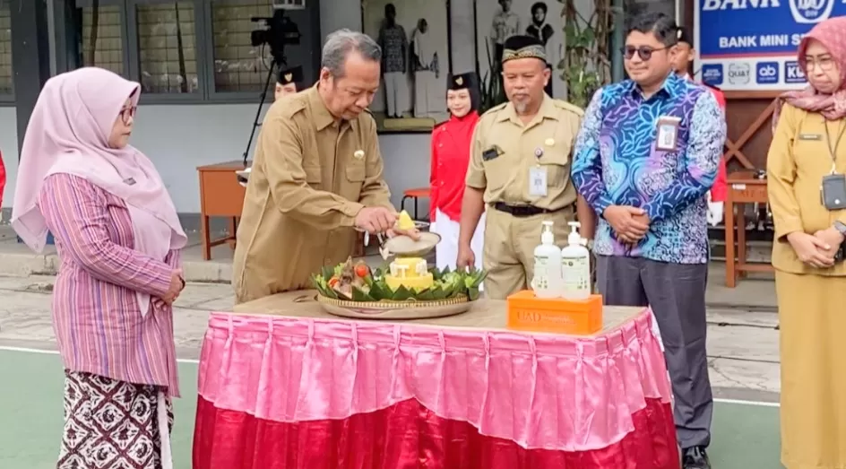   Kepala Dikpora DIY,  Suhirman didampingi Isti Fatimah (kiri) memotong tumpeng. (Sukro Riyadi)