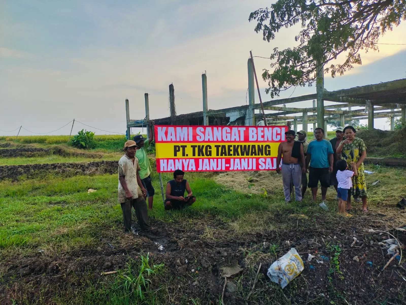Warga memasang spanduk desakan PT TKG Taekwang untuk segera merealisasikan pendirian pabrik (foto: said masykuri)