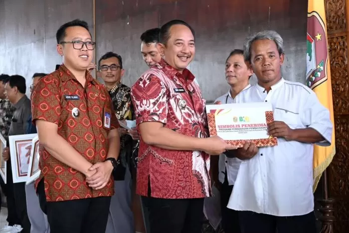 Bupati Karanganyar Rober Christanto menyerahkan simbolis ketetapan penghapusan PBB bagi warga miskin (foto:Abdul Alim)