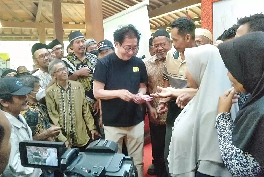 Irwan Hidayat membagikan banus kepada para perwakilan dhuafa yang hadir di pabrik Sidomuncul. (Budiono)