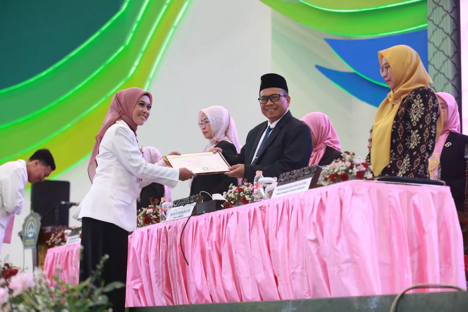 Rektor saat menyerahkan ijazah kepada apoteker baru