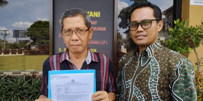 Korban AW didampingi Farid Iskandar, menunjukkan bukti laporan. 
