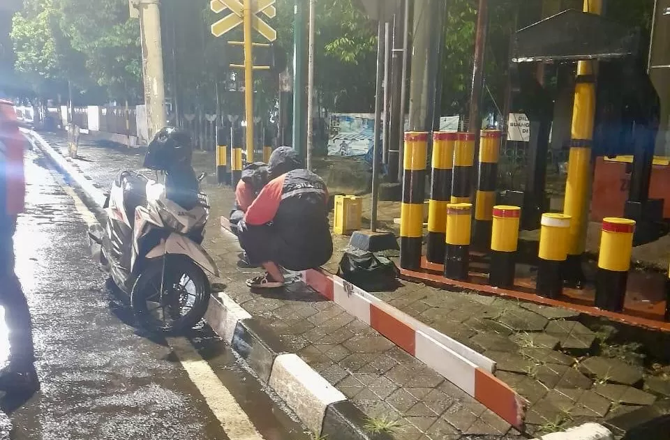 Petugas saat membetulkan palang perlintasan yang rusak ditabrak mobil (ist)