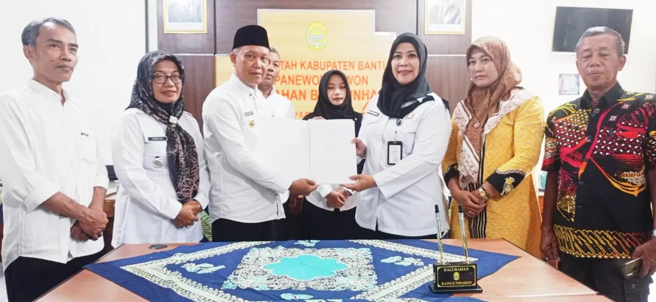  Kepala Divisi Pelayanan Hukum Kanwil Kemenkum DIY, Eem Nurmanah  (kanan) menyerahkan akta Koperasi Merah Putih kepada Lurah Bangunharjo, Nur Hidayat. (Sukro Riyadi)