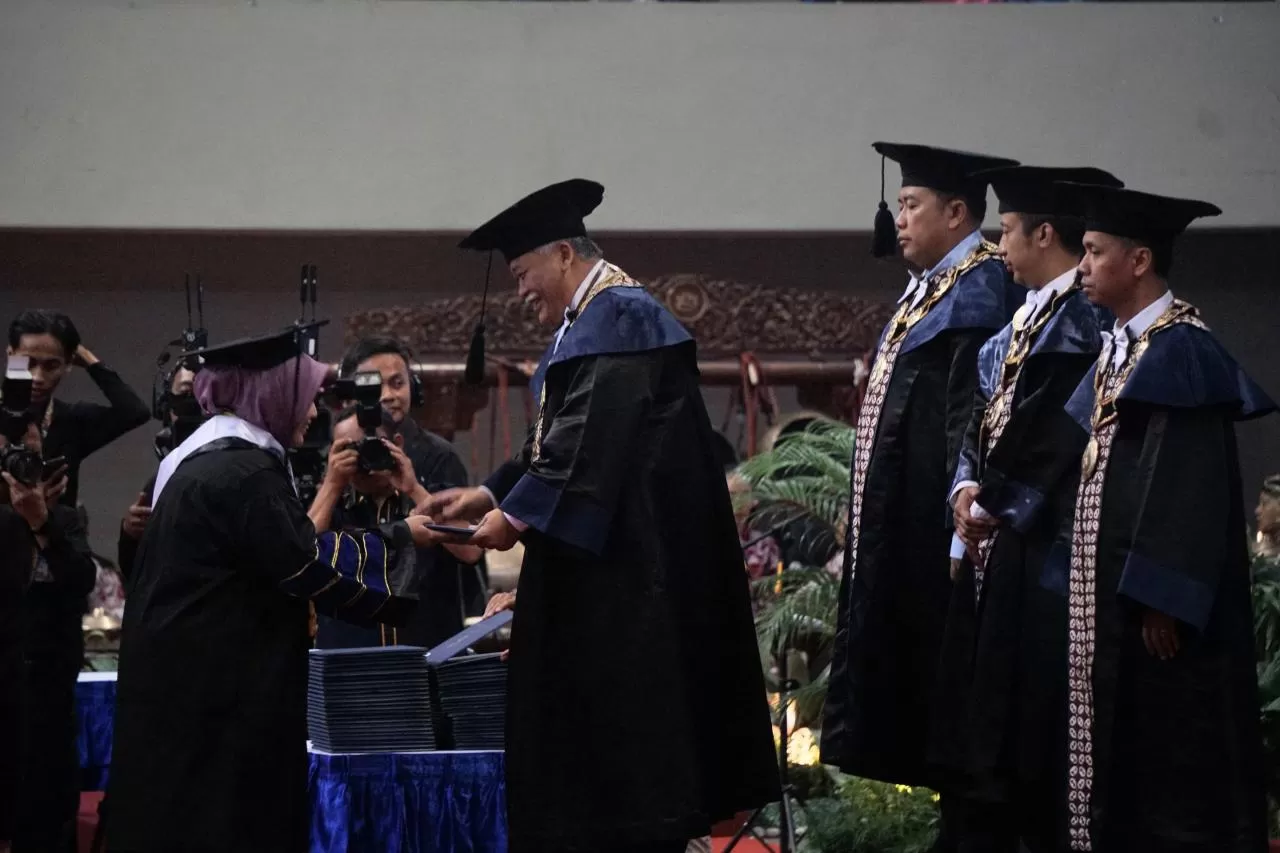  Rektor UNY, Prof Dr Sumaryanto MKes AIFO menyerahkan ijazah kepada wisudawan dalam upacara wisuda periode I tahun akademik 2025/2026 di GOR UNY, Selasa (26/8).   ( Foto : Adhitya Asros)