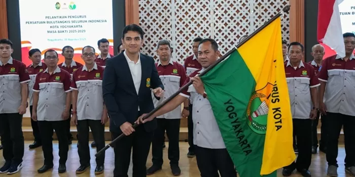 Ketum Pengda PBSI DIY (kiri) menyerahkan pataka (bendera PBSI) kepada Agus Riyanto.