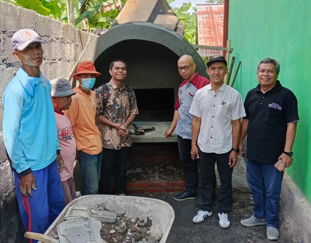 Tim pengabdian UJB bersama warga di depan incinerator ramah lingkungan yang baru saja selesai dibangun. (Istimewa)