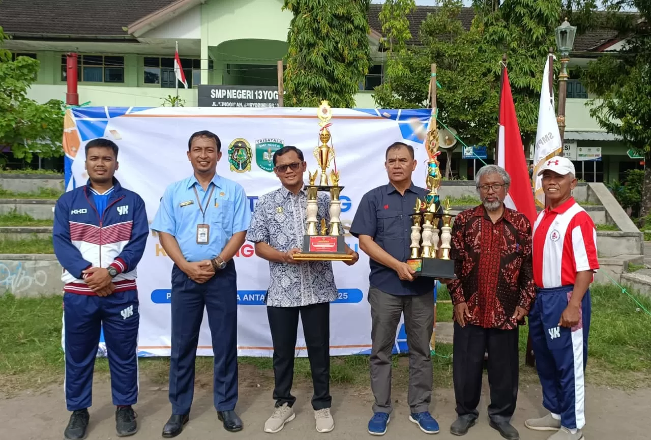 Perwakilan SMPN 13 Yogyakarta bersama Disdikpora DIY berpose sambil memegang piala juara umum POR KKO DIY. (Foto: Agito)